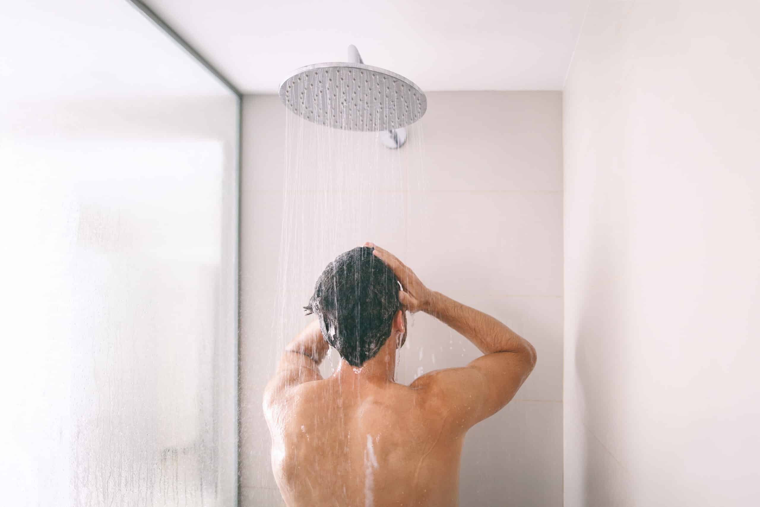 Man taking a shower with hard water