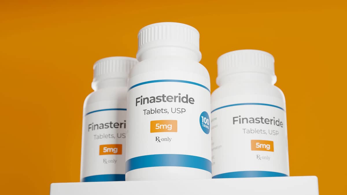 Finasteride tablets bottle on orange background. 5-Alpha reductase inhibitor. Prevents formation of DHT. 3d rendering