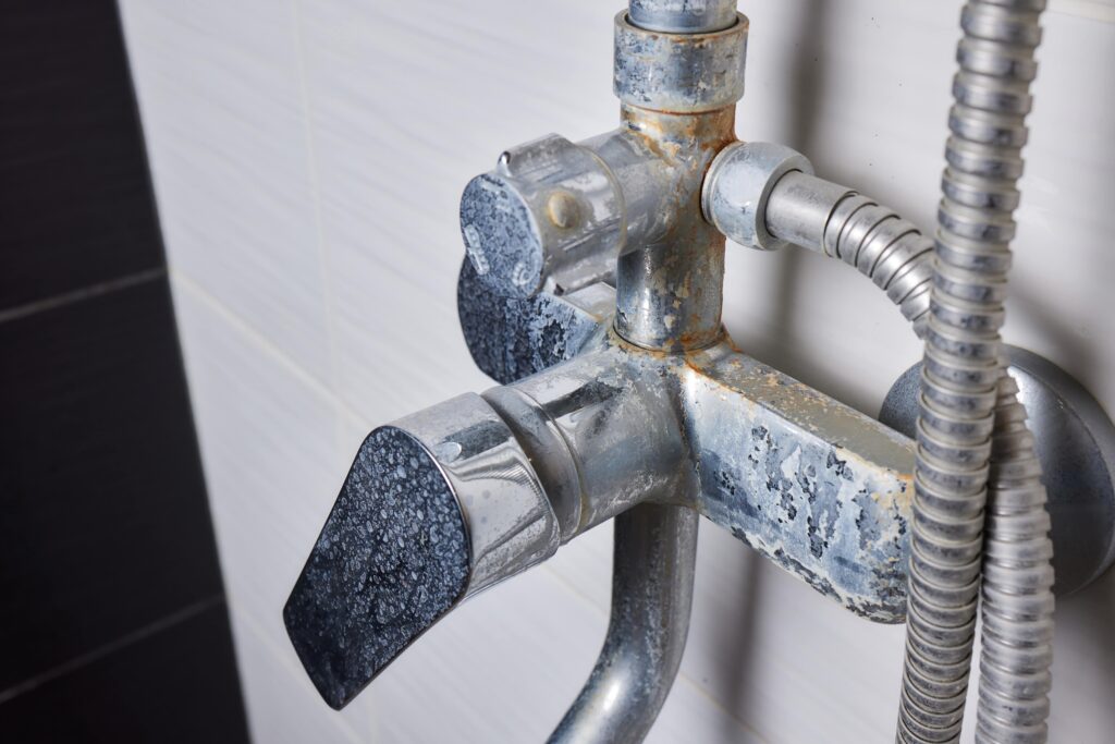 Vieux robinet d'évier de salle de bains encrassé par l'eau dure.