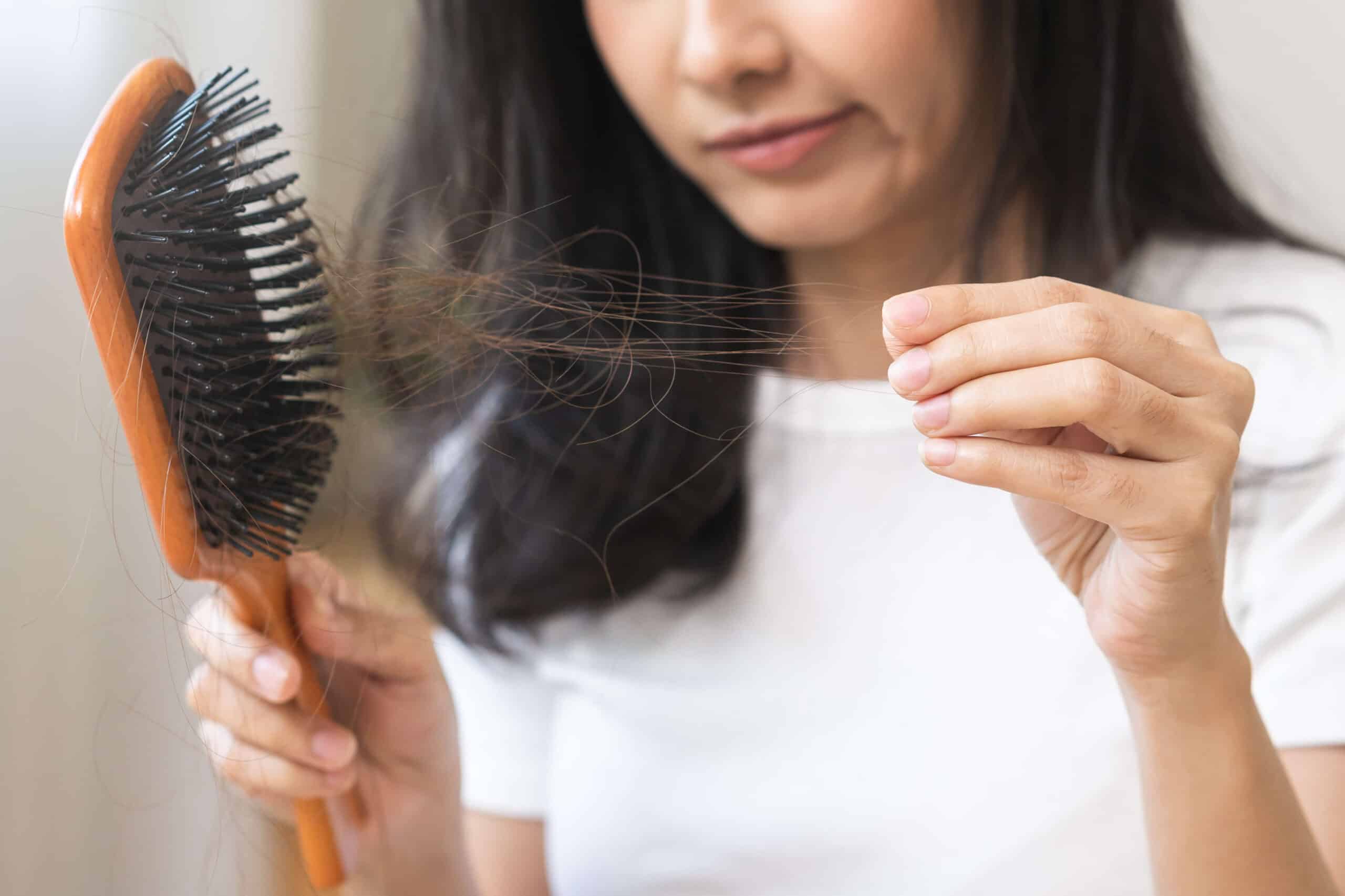 Woman looking at the hairs she's losing