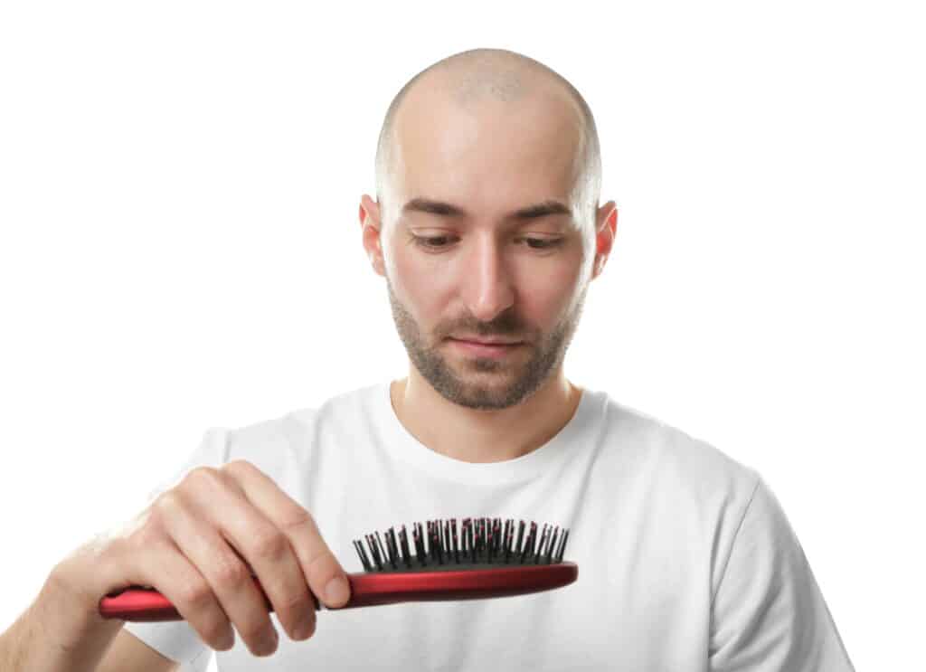 Young man with hair comb on white background